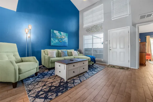 a living room with furniture and a wooden floor