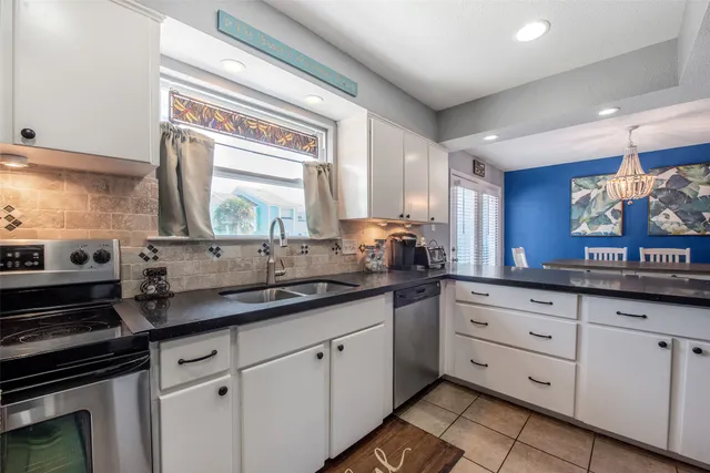 a kitchen with granite countertop white cabinets and white appliances