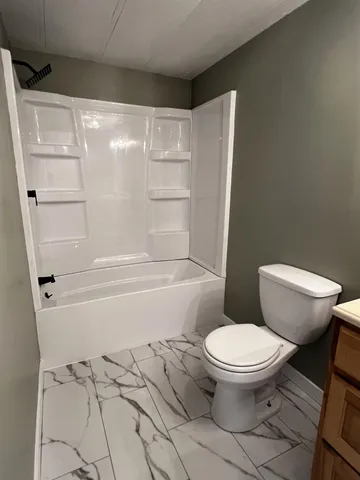 a bathroom with a toilet and a shower