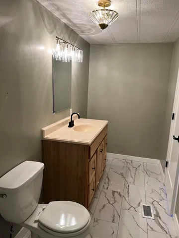 a bathroom with a sink a toilet and mirror