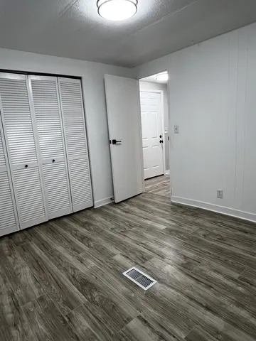 an empty room with wooden floor and window