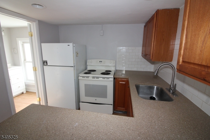 171 Stanton Road, Unit A Flemington, NJ 08822 - Photo 2 of 12 a kitchen with a refrigerator a stove a sink and a window
