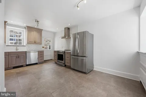 a kitchen with stainless steel appliances a refrigerator sink and cabinets