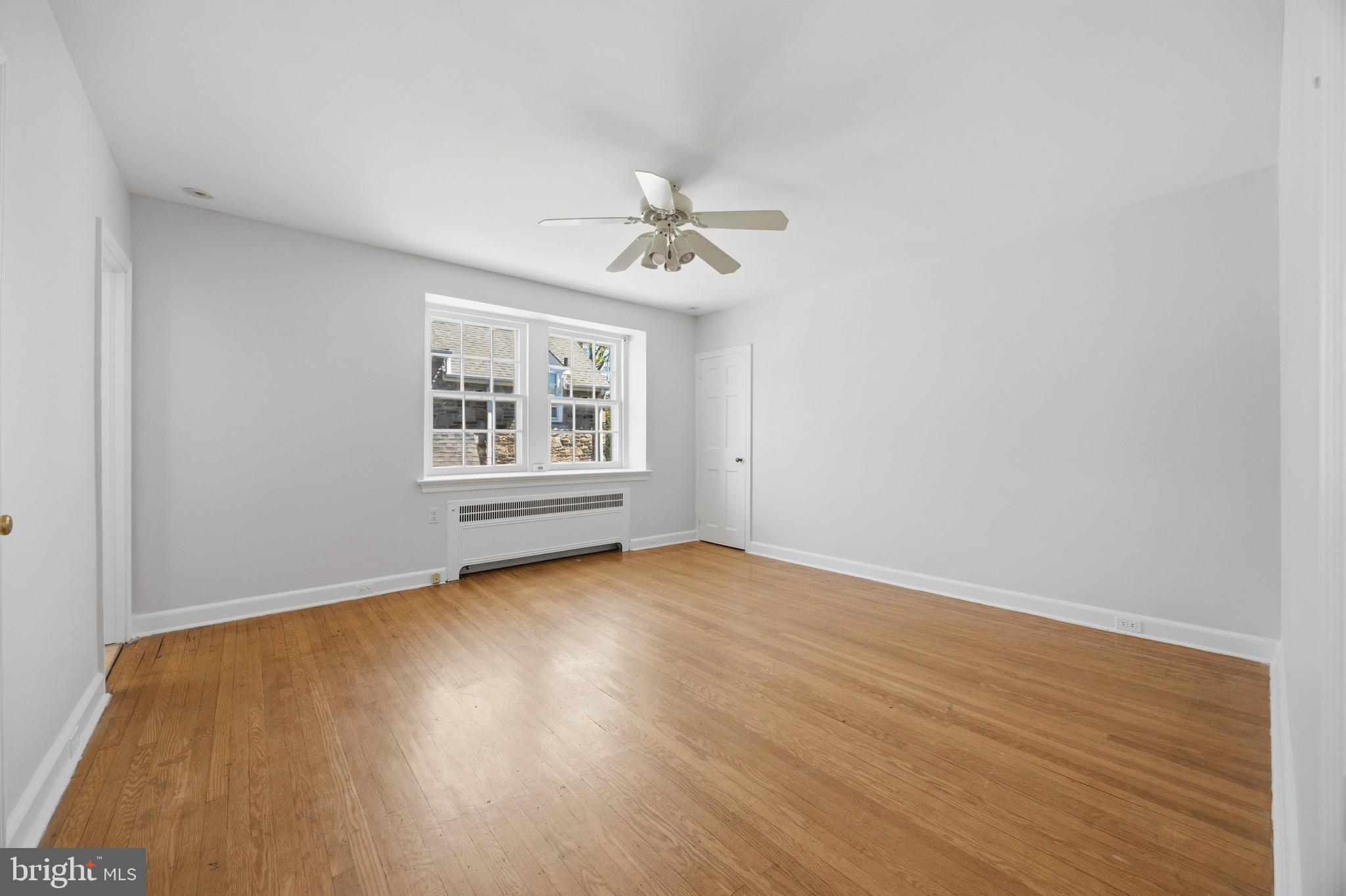 326 Winding Way Merion Station, PA 19066 - Photo 23 of 33 an empty room with wooden floor ceiling fan and windows