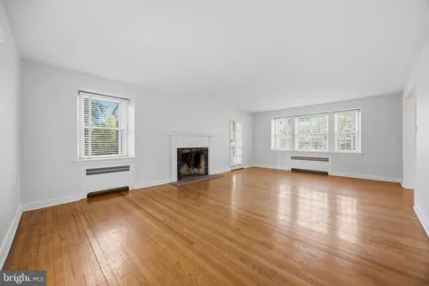 a view of empty room with wooden floor and fireplace