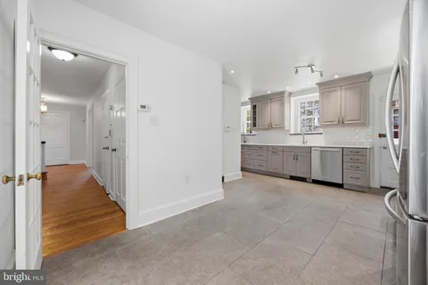 a view of a kitchen with white cabinets and stainless steel appliances
