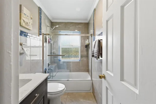 a bathroom with a bathtub shower sink vanity mirror and toilet