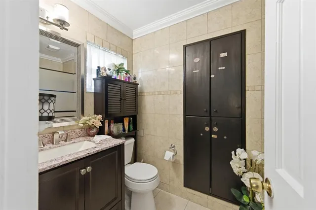a bathroom with a granite countertop sink a toilet and mirror