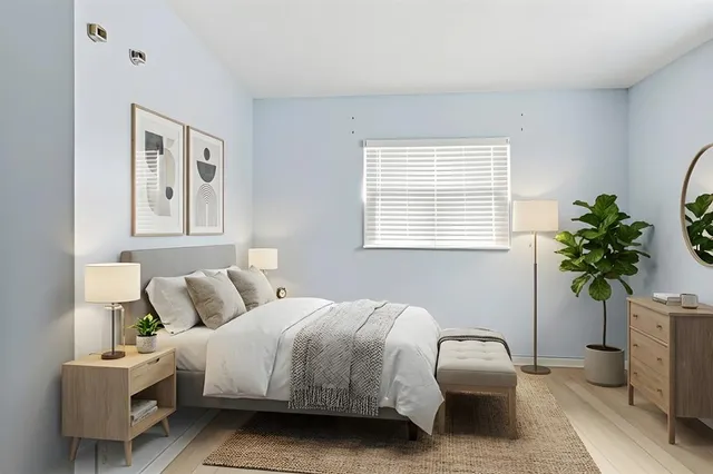 a bedroom with a bed and a potted plant