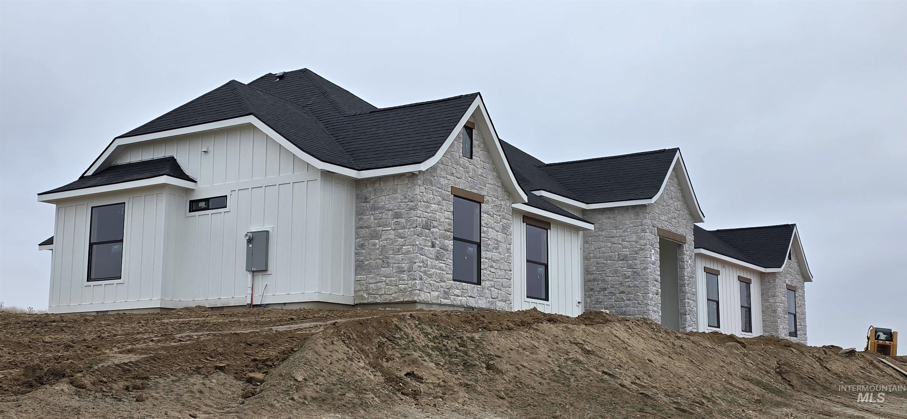 17244 Triple Crown Place Caldwell, ID 83607 - Photo 4 of 8 View of side of property with stone siding, board and batten siding, and a shingled roof