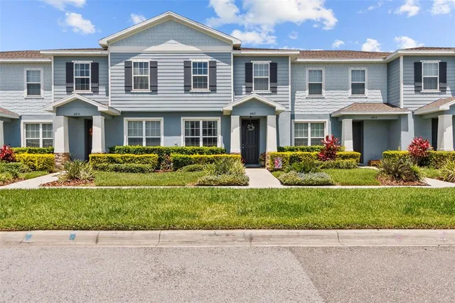 a front view of a house with a yard and potted plants