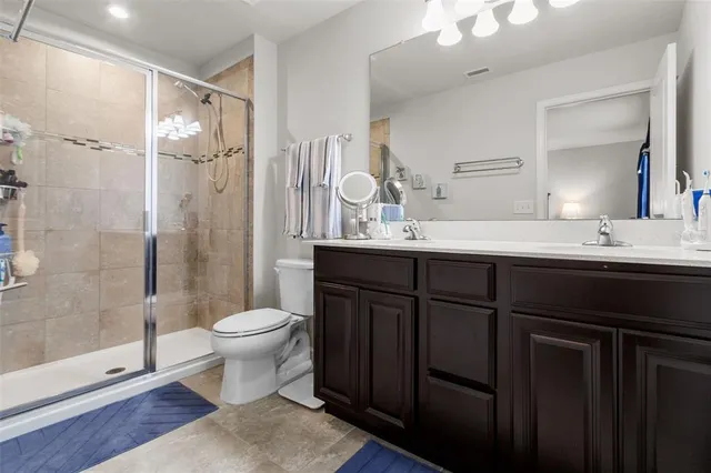 a bathroom with a double vanity sink toilet and shower