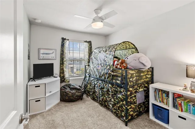 a bedroom with furniture a flat screen tv and a window