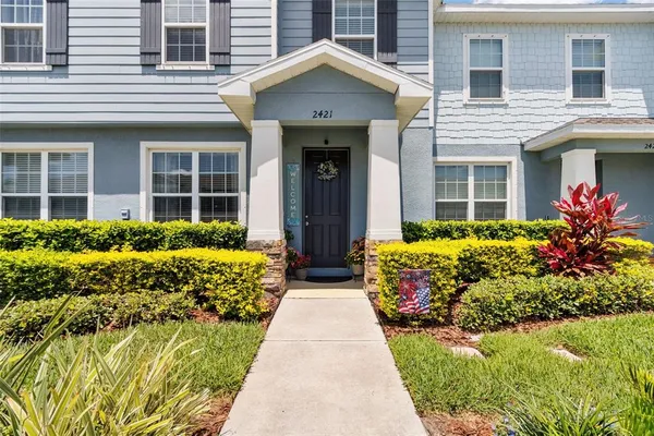 a front view of a house with a yard and potted plants