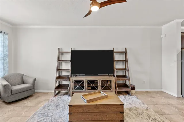 a living room with furniture a flat screen tv and a table
