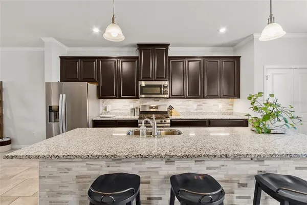 a kitchen with granite countertop cabinets stainless steel appliances and a counter space