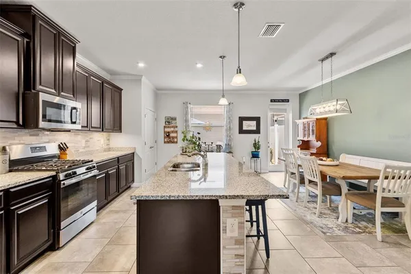 a large kitchen with lots of counter space a sink and stainless steel appliances