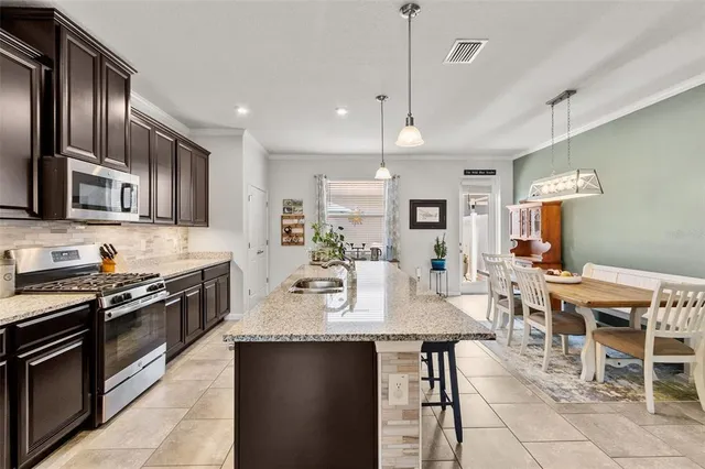 a large kitchen with lots of counter space a sink and stainless steel appliances