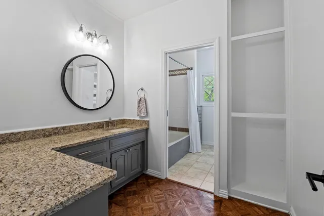 a bathroom with a double vanity sink toilet and shower