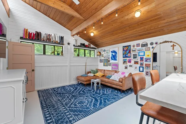 a kitchen with stainless steel appliances kitchen island granite countertop a refrigerator and a view of living room