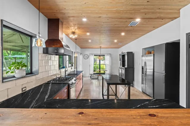 a kitchen with stainless steel appliances granite countertop a stove a sink and a refrigerator