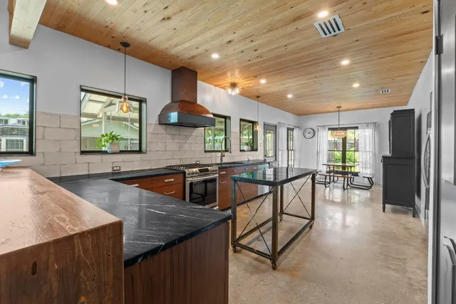 a kitchen with stainless steel appliances granite countertop table chairs and a refrigerator