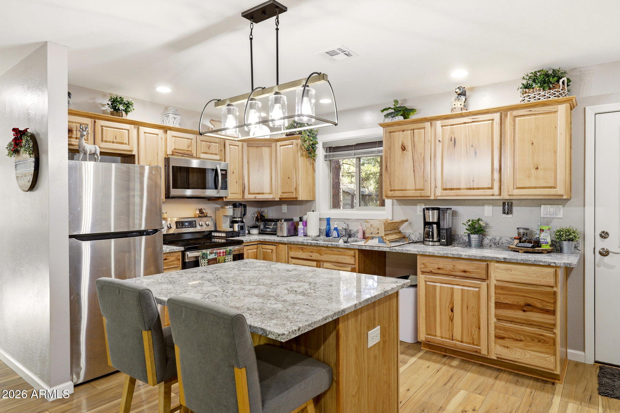 2900 Long Rifle Place Overgaard, AZ 85933 - Photo 9 of 35 a kitchen with stainless steel appliances granite countertop a sink a stove a refrigerator cabinets and chairs