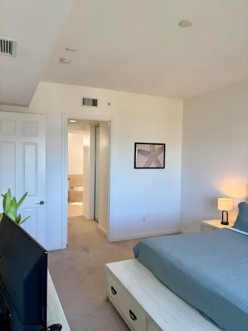 a bedroom with a bed and a potted plant