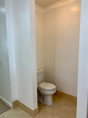 a white toilet sitting next to a white wall