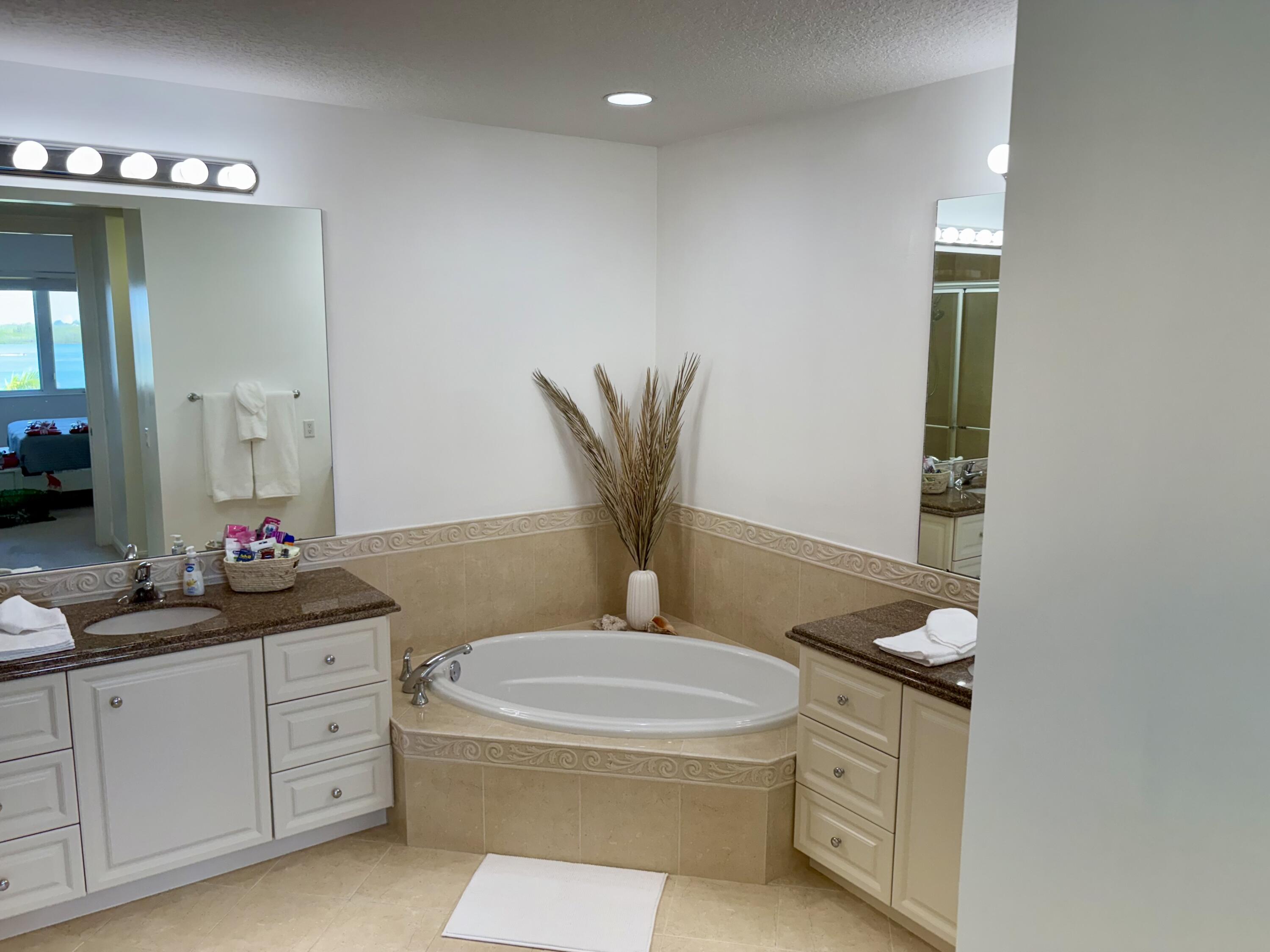 38 Harbour Isle Drive East, Unit PH01 Fort Pierce, FL 34949 - Photo 20 of 30 a bathroom with a granite countertop toilet sink and mirror