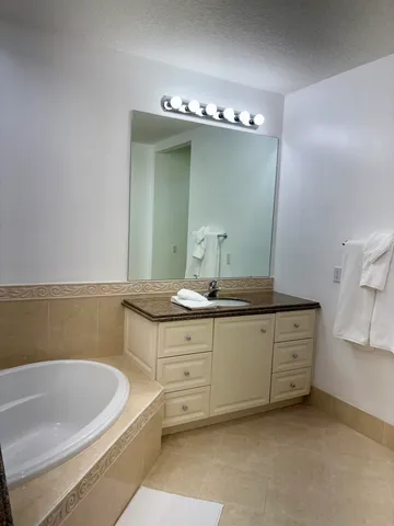a bathroom with a bathtub sink and mirror