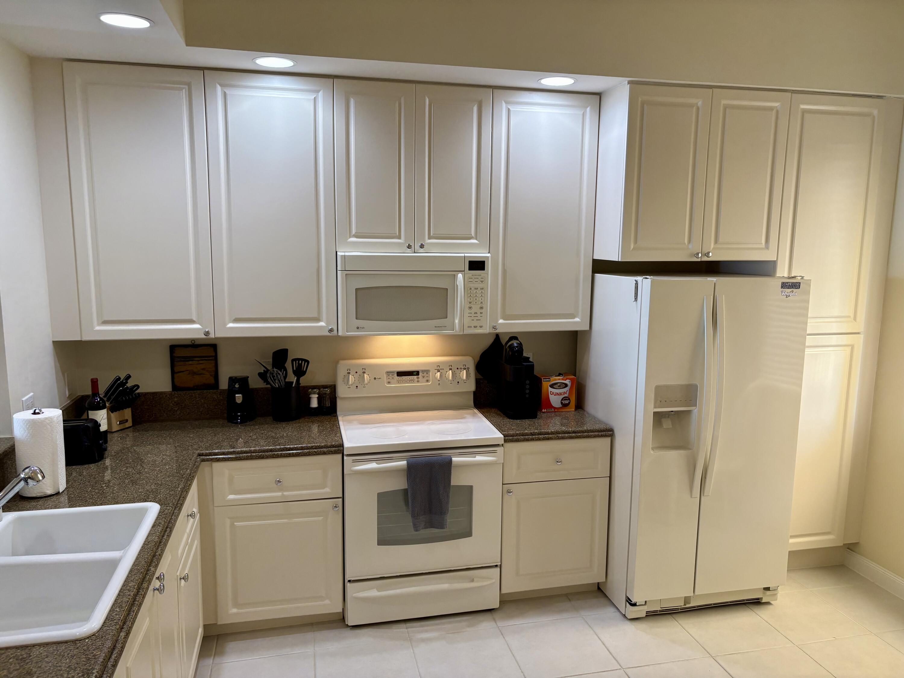 38 Harbour Isle Drive East, Unit PH01 Fort Pierce, FL 34949 - Photo 3 of 30 a kitchen with white cabinets and white appliances