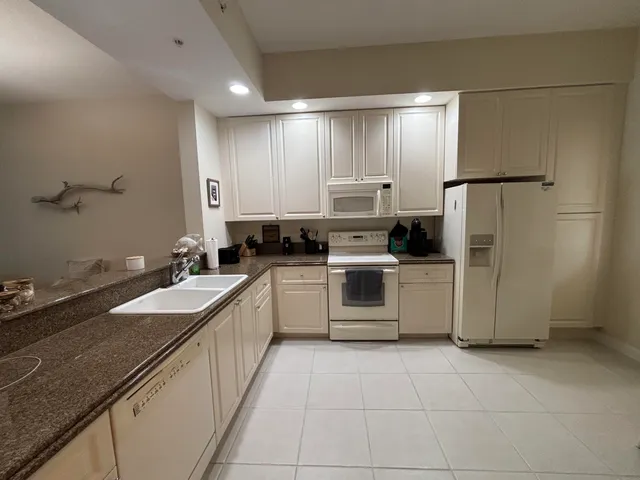 a kitchen with a sink refrigerator and cabinets