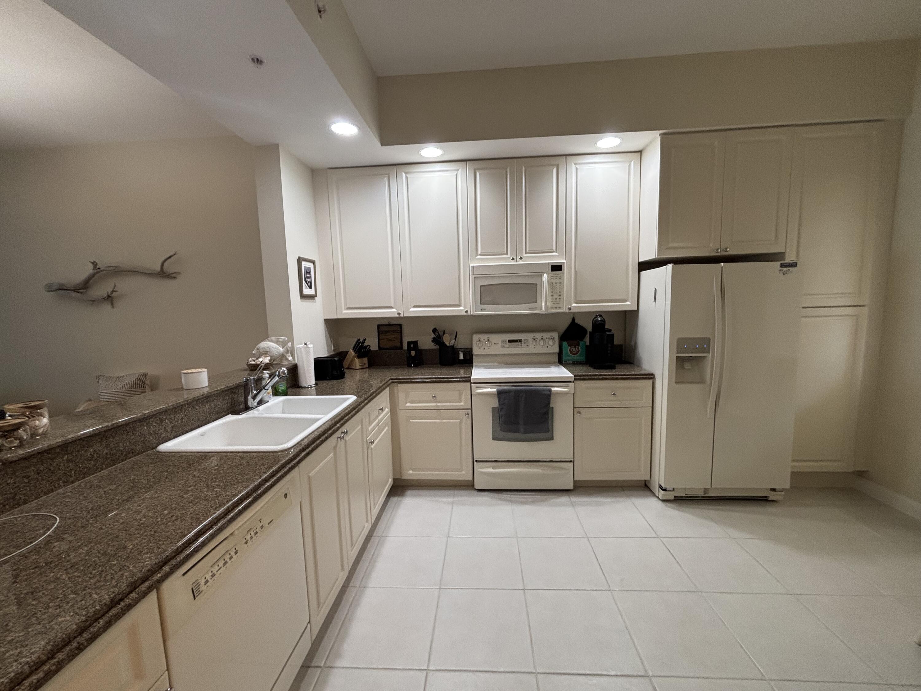 38 Harbour Isle Drive East, Unit PH01 Fort Pierce, FL 34949 - Photo 4 of 30 a kitchen with a sink refrigerator and cabinets