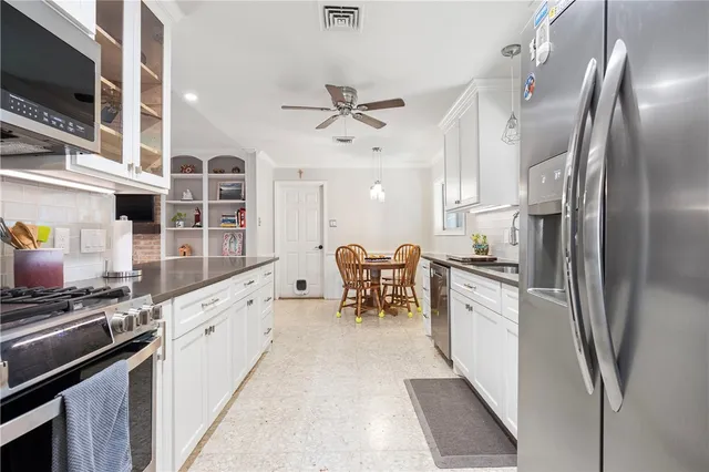 a kitchen with stainless steel appliances kitchen island granite countertop a refrigerator stove and sink