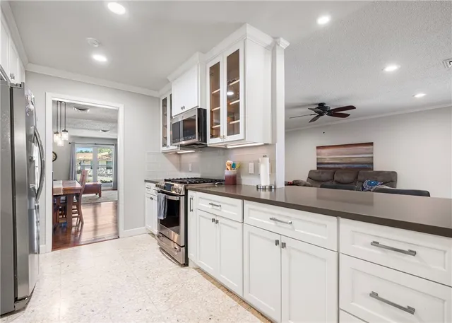 a kitchen with granite countertop kitchen island a sink stainless steel appliances and cabinets