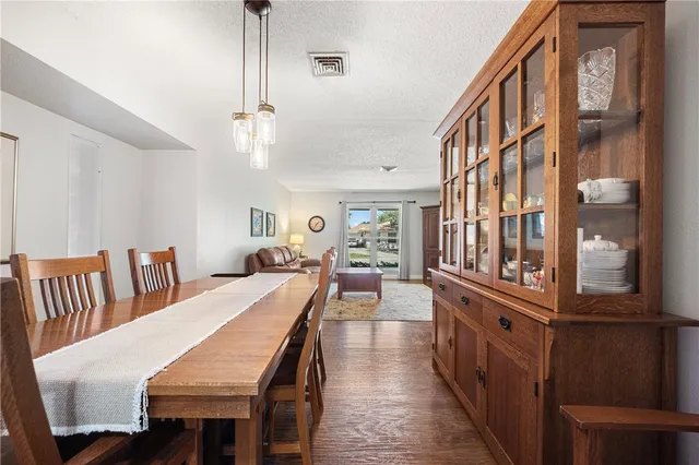 a dining room with wooden floor and furniture