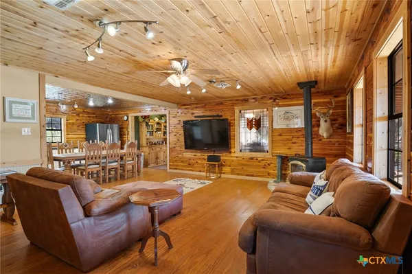 a living room with stainless steel appliances kitchen island a stove and a refrigerator
