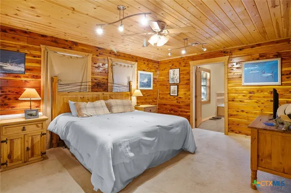 a spacious bedroom with a bed and a flat screen tv