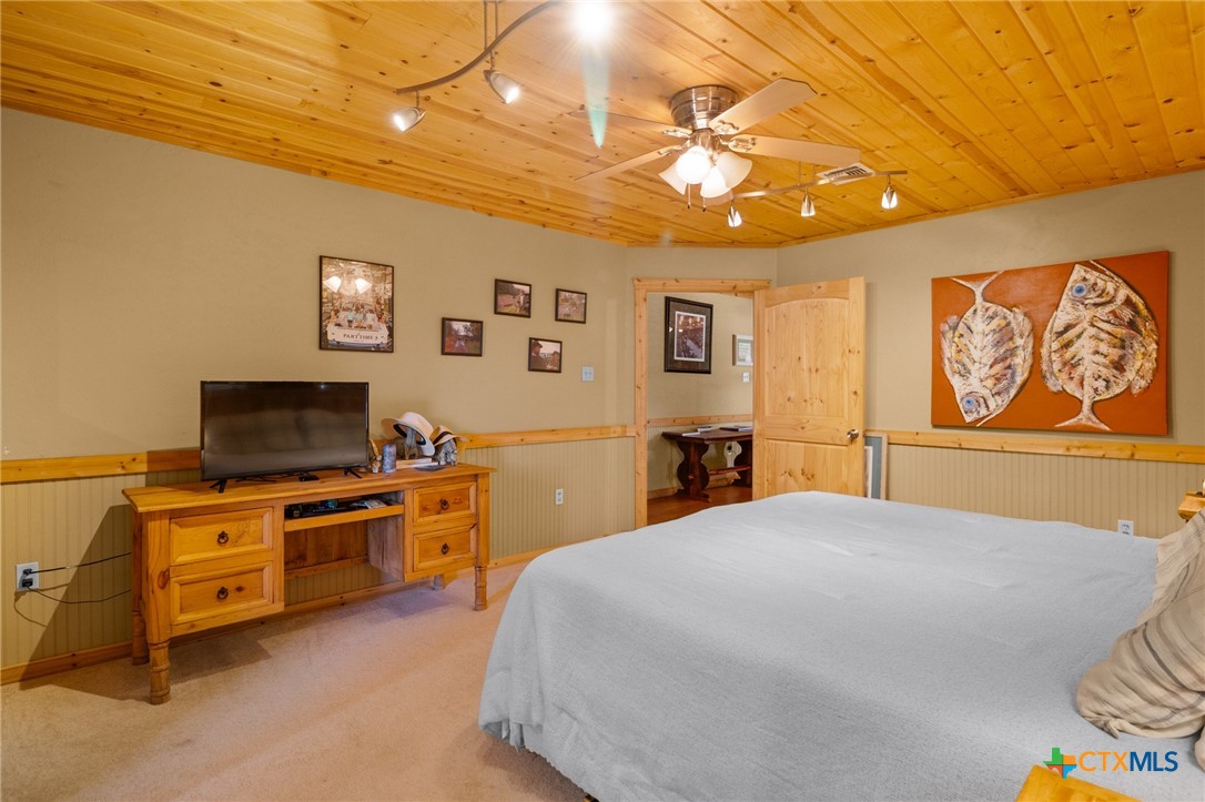 1465 County Road 401 Edna, TX 77957 - Photo 25 of 46 a spacious bedroom with a bed and a flat screen tv