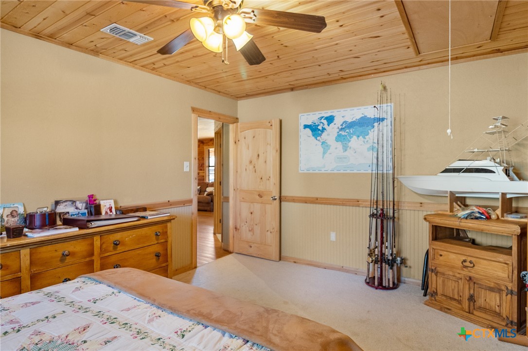 1465 County Road 401 Edna, TX 77957 - Photo 30 of 46 a bedroom with a bed and a chandelier