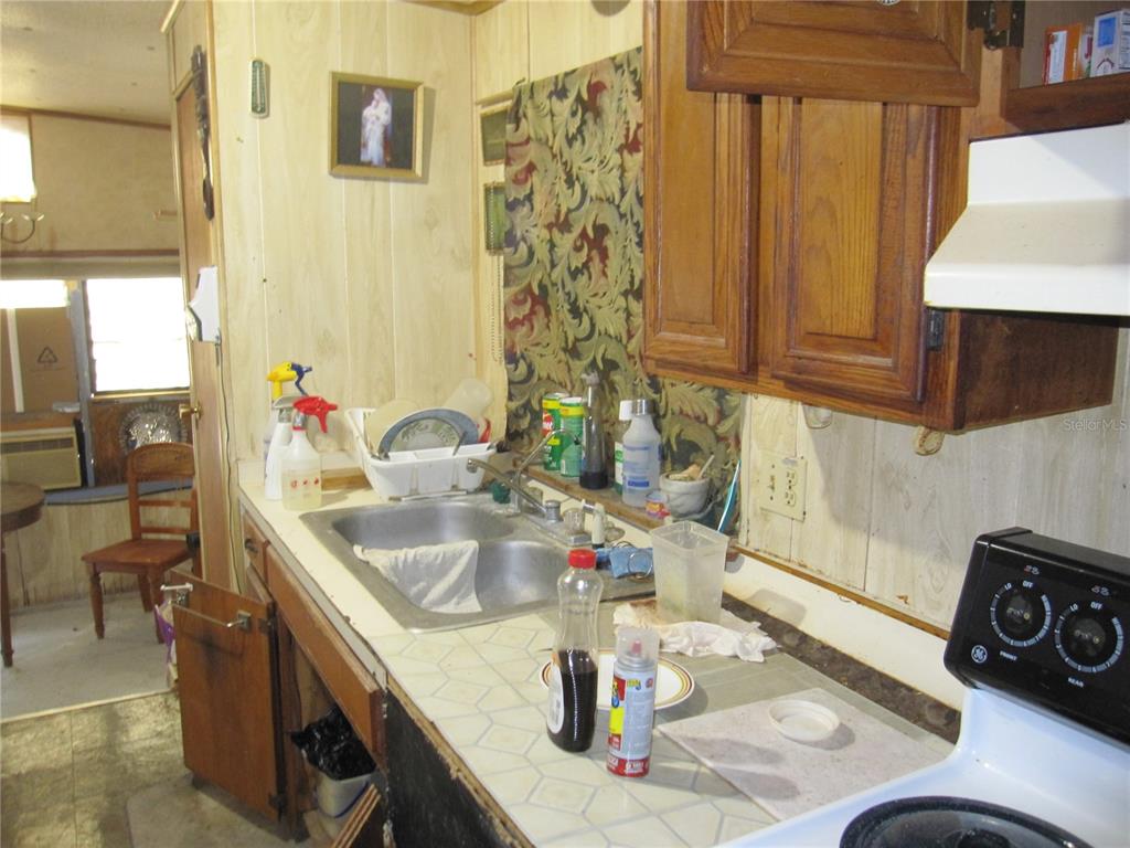 37736 Phelps Road Zephyrhills, FL 33541 - Photo 23 of 30 a kitchen with a sink stove and a microwave oven
