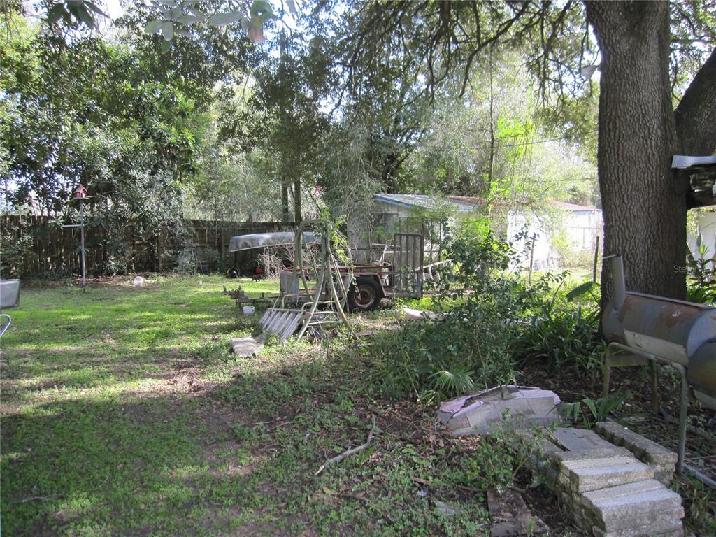 37736 Phelps Road Zephyrhills, FL 33541 - Photo 4 of 30 a backyard of a house with table and chairs large trees