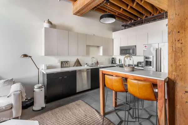 a kitchen with a sink appliances cabinets and furniture