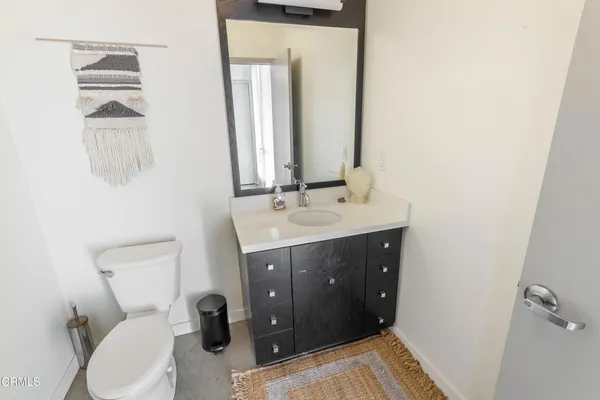 a bathroom with a sink vanity mirror and toilet