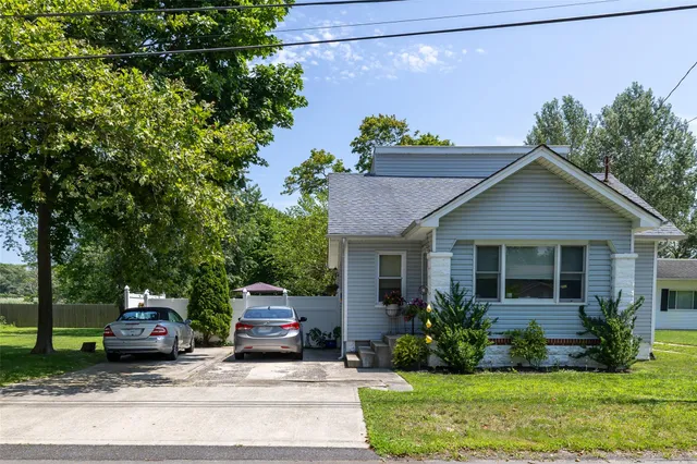 a front view of a house with a yard and potted plants