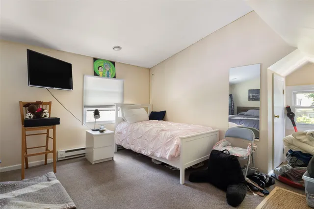 a bedroom with a bed a flat screen tv and dresser