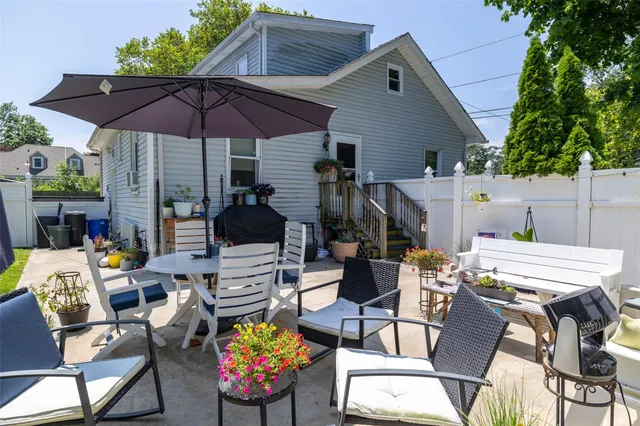 a patio with a table and chairs under an umbrella