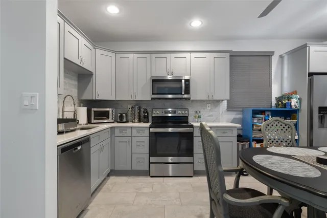 a kitchen with granite countertop a sink stove and cabinets