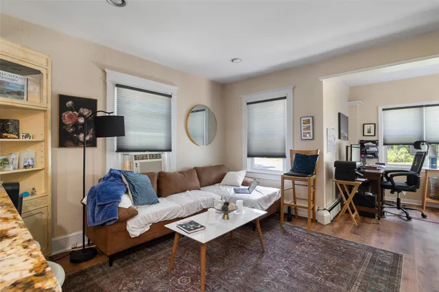 a living room with furniture a rug and a table